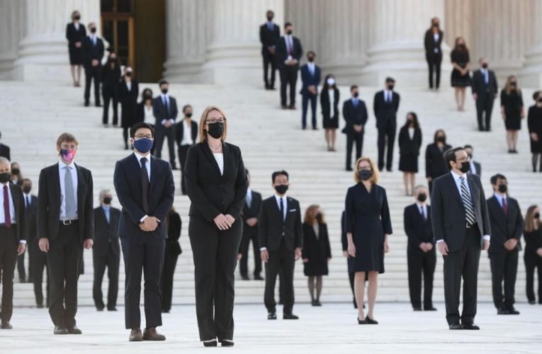 An army of more than 100 of former clerks accompany Ruth Bader Ginsburg’s casket up the stone steps