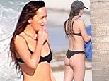 Dakota Johnson rocks a black bikini at a beach while beau Chris Martin plays with son Moses