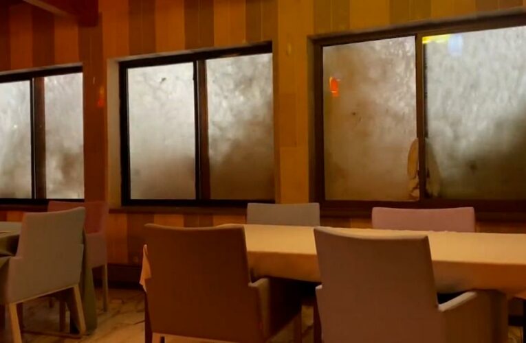 Waves slam against hotel window during winter storm